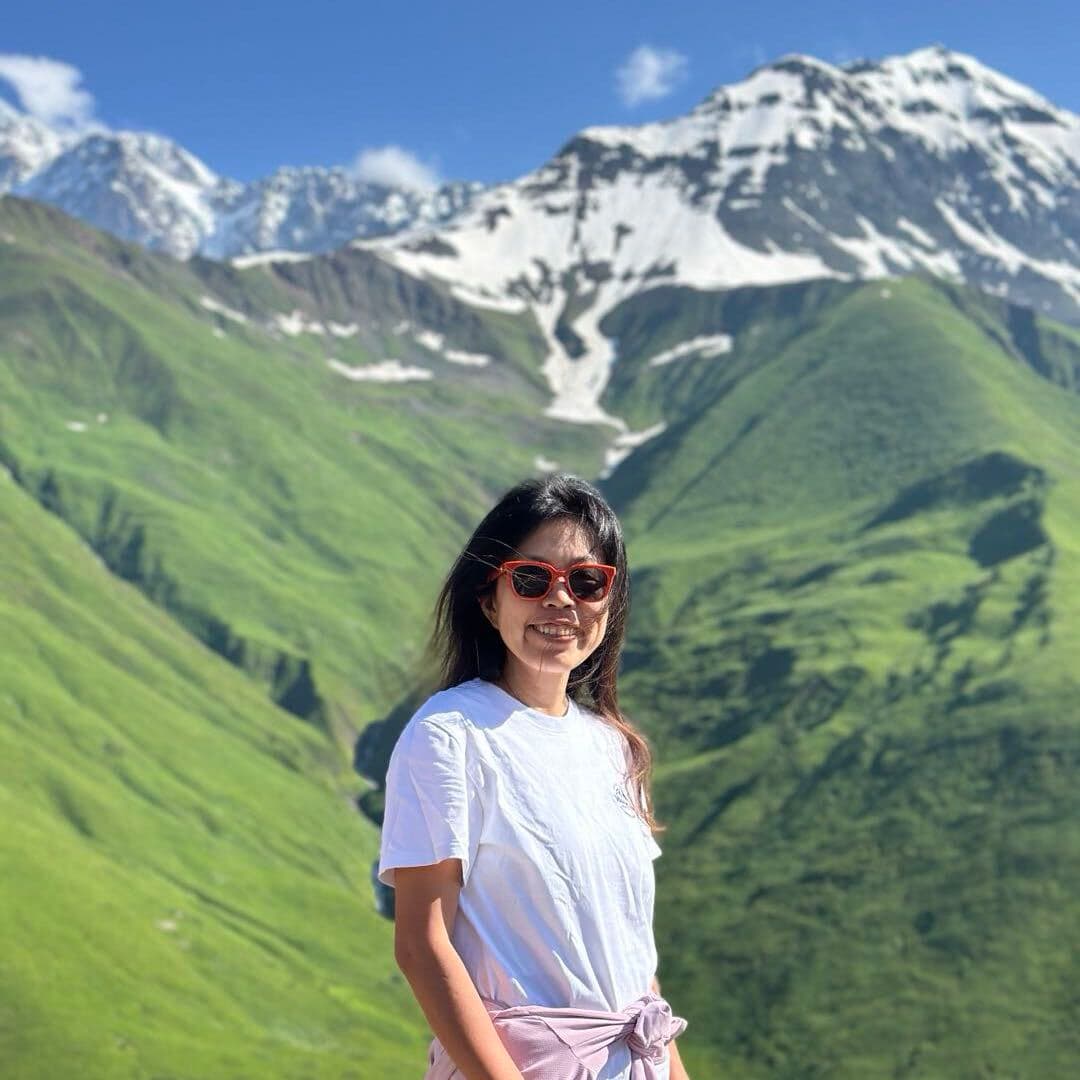 Dana standing in front of green mountains in Beijing